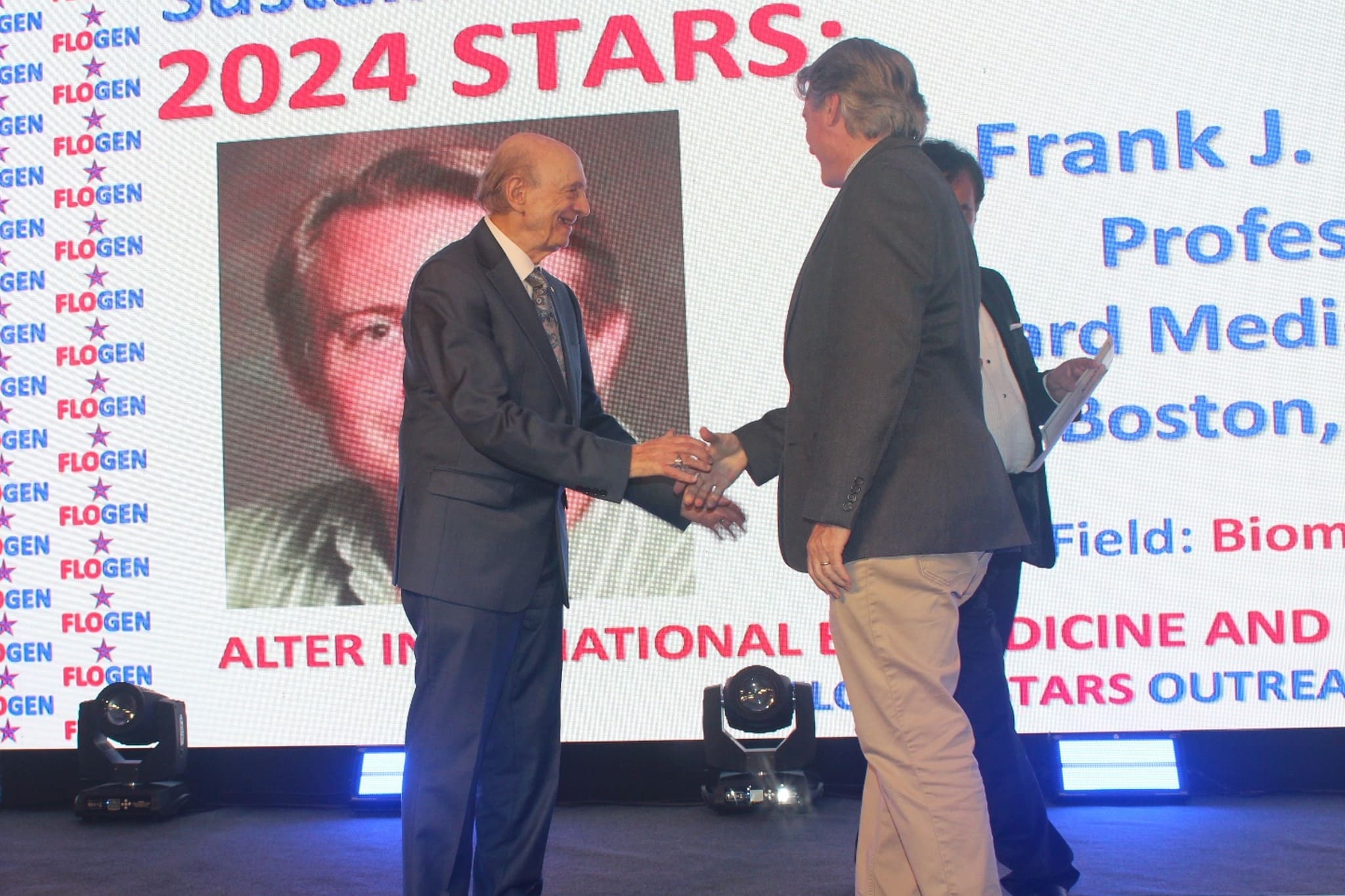 Dr. Harvey J. Alter congratulating Dr. Frank J. Slack during the FLOGEN SIPS 2024 award ceremony