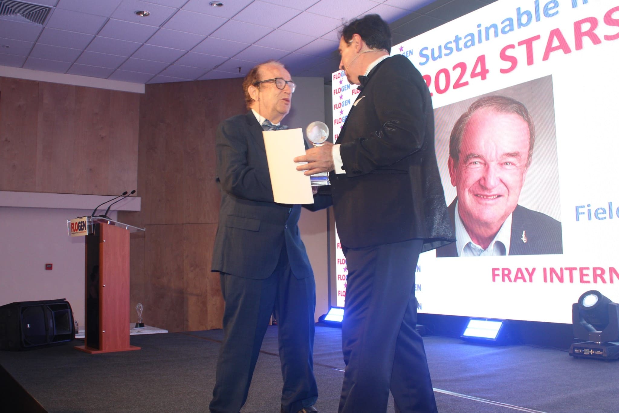Dr. Florian Kongoli congratulating Dr. Hans Leuenberger during the FLOGEN SIPS 2024 award ceremony