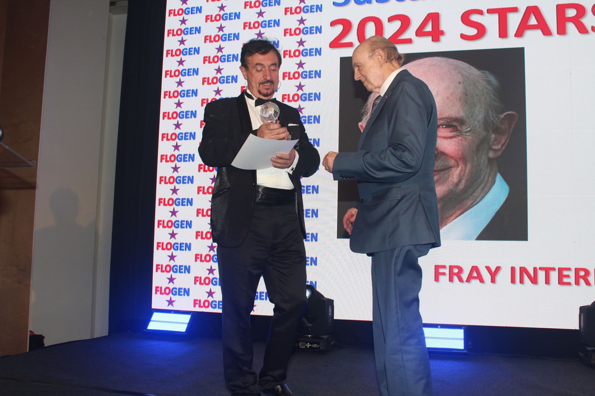 Dr. Florian Kongoli congratulating Dr. Harvey J. Alter during the FLOGEN SIPS 2024 award ceremony