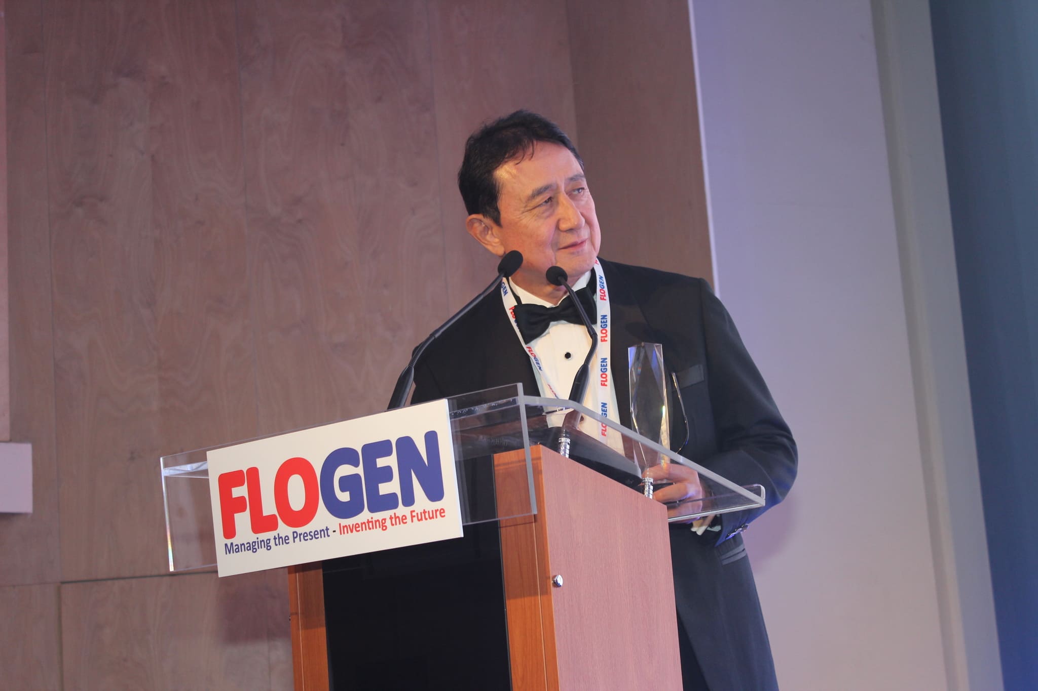 Dr. Haruhiko Inufusa delivering an acceptance speech on behalf of Dr. Koji Abe during the FLOGEN SIPS 2024 award ceremony