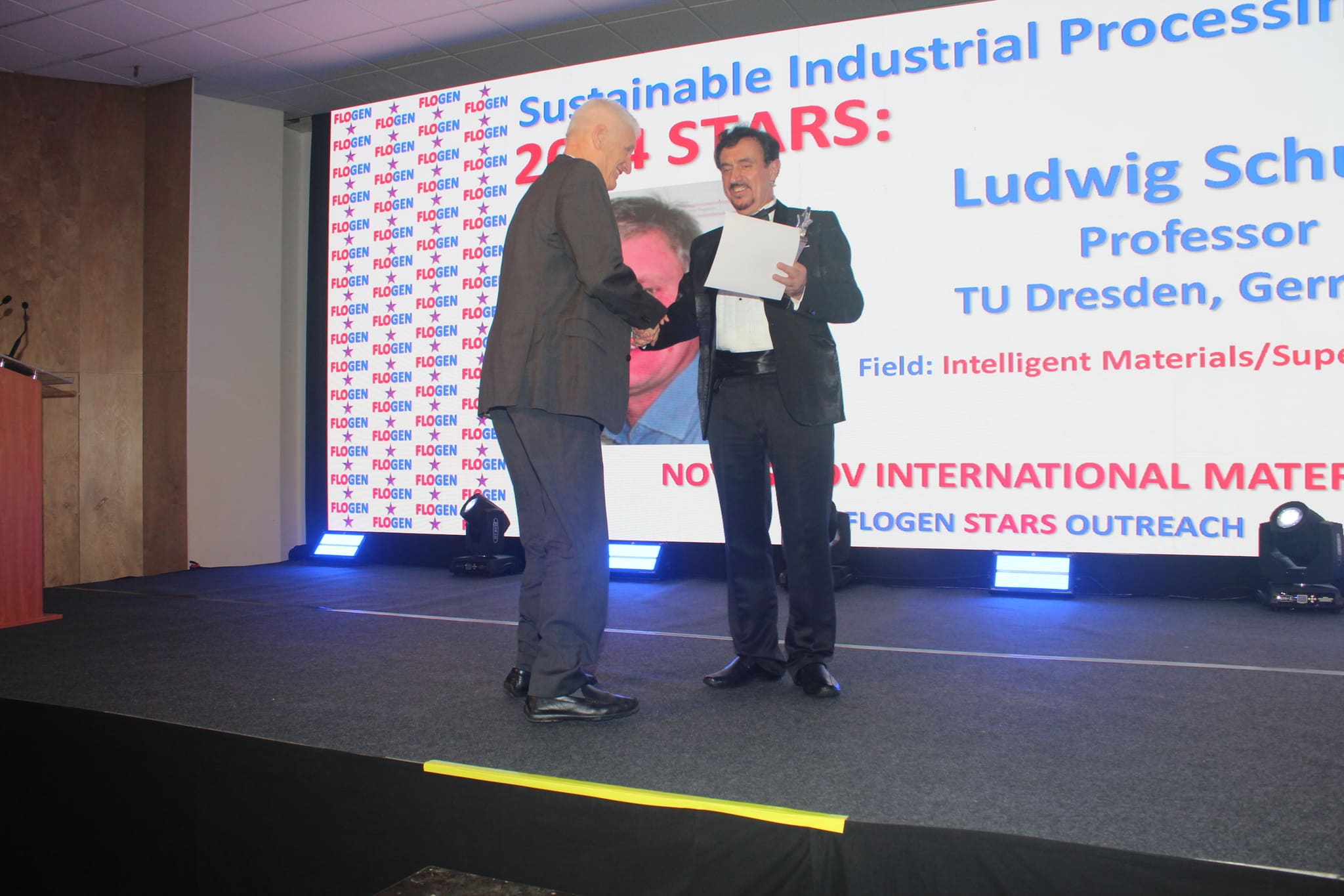 Dr. Florian Kongoli congratulating Dr. Ludwig Schultz during the FLOGEN SIPS 2024 award ceremony