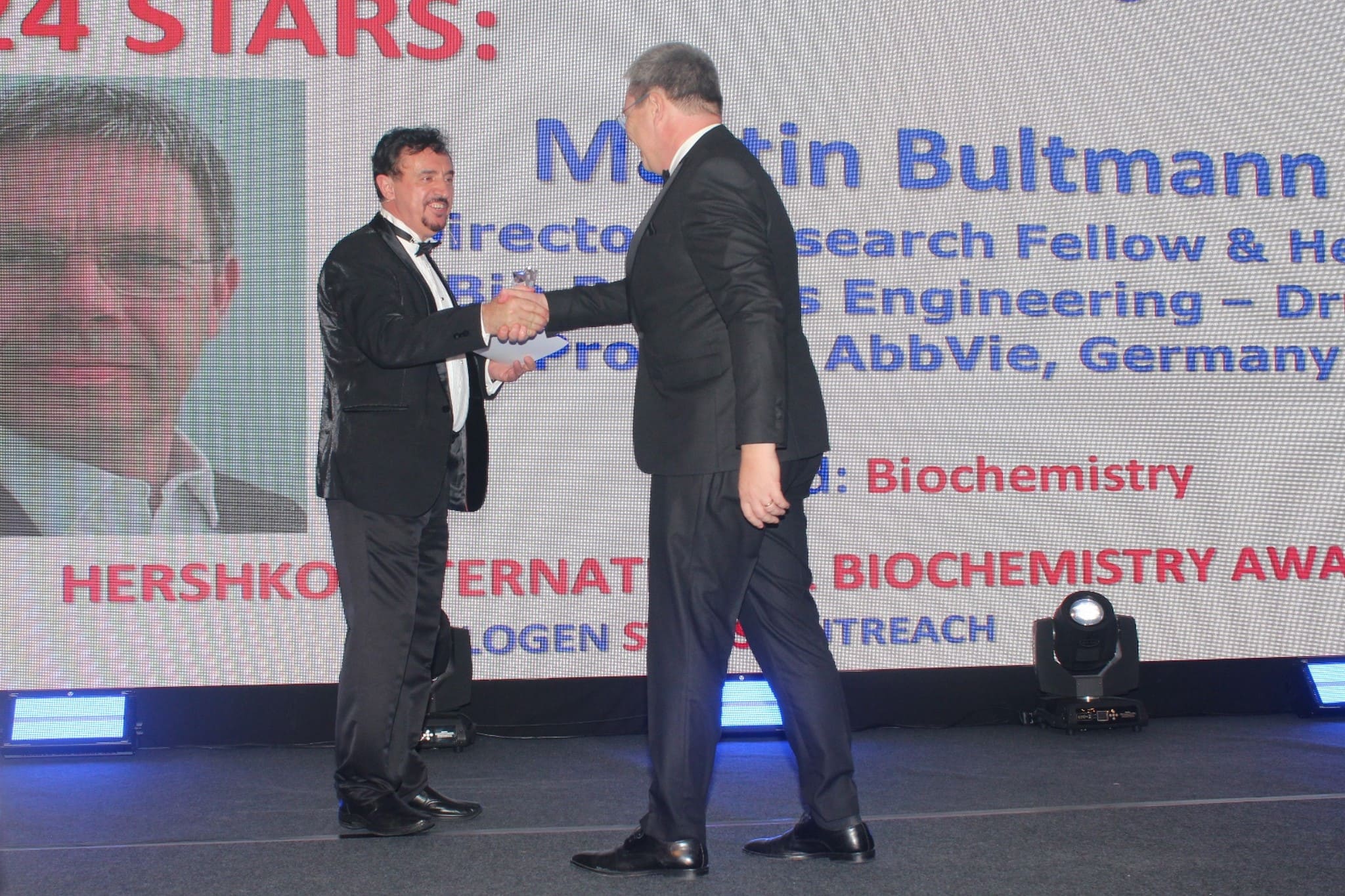 Dr. Florian Kongoli congratulating Dr. Martin Bultmann during the FLOGEN SIPS 2024 award ceremony