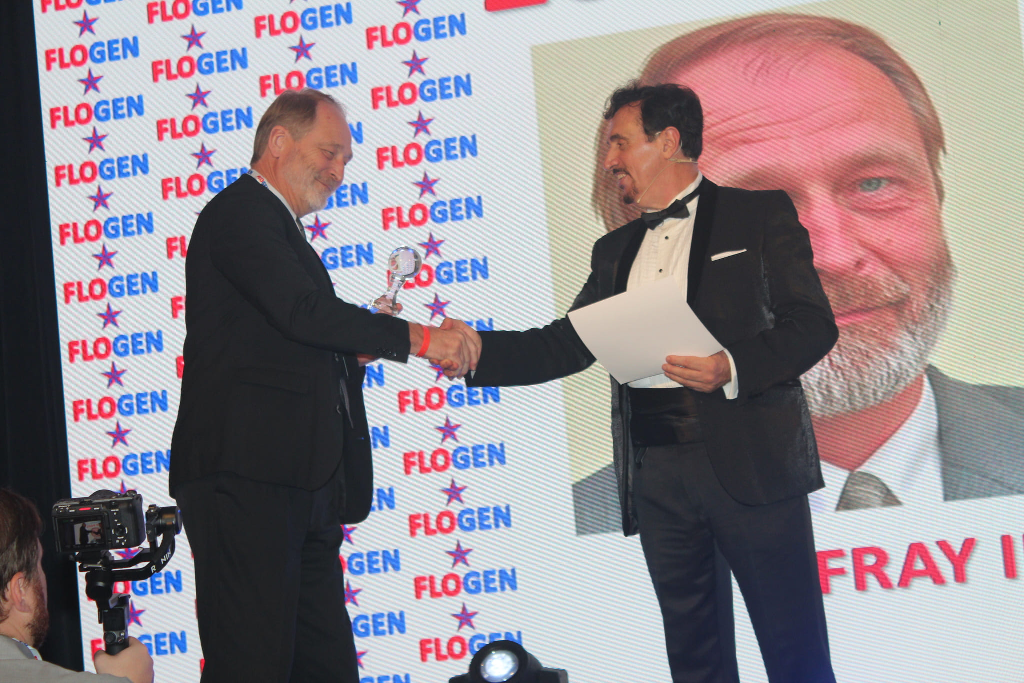 Dr. Florian Kongoli congratulating Dr. Michael Stelter during the FLOGEN SIPS 2024 award ceremony