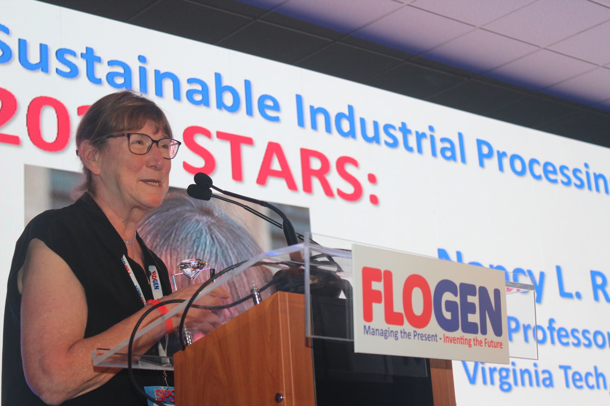 Dr. Nancy Ross delivering an acceptance speech during the FLOGEN SIPS 2024 award ceremony