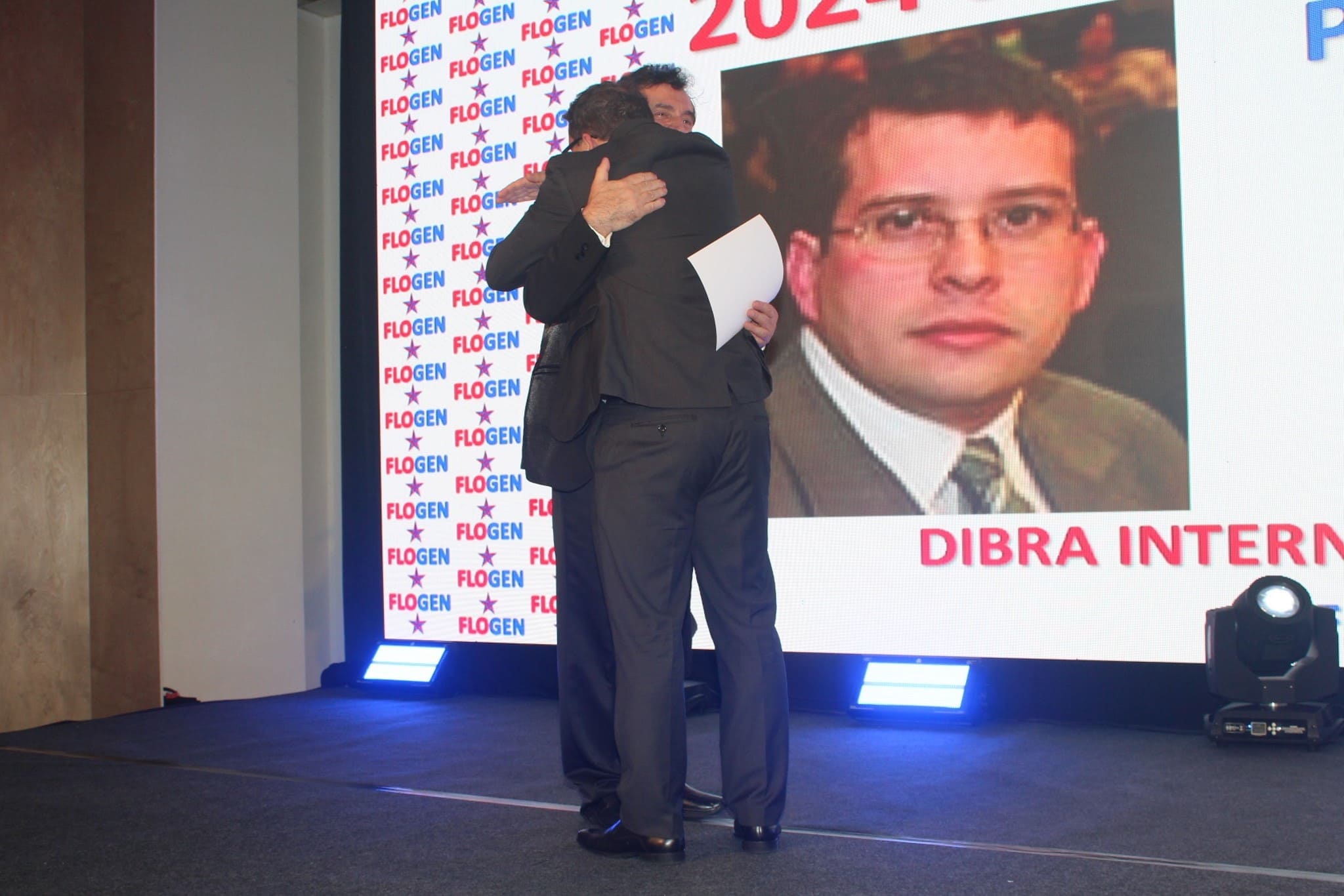 Dr. Florian Kongoli congratulating Dr. Pierre da Silva Moraes during the FLOGEN SIPS 2024 award ceremony