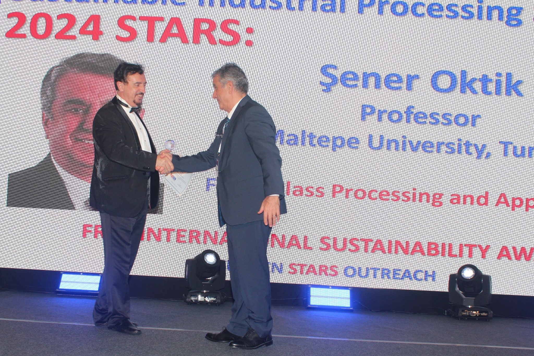 Dr. Florian Kongoli congratulating Dr. Sener Oktik during the FLOGEN SIPS 2024 award ceremony