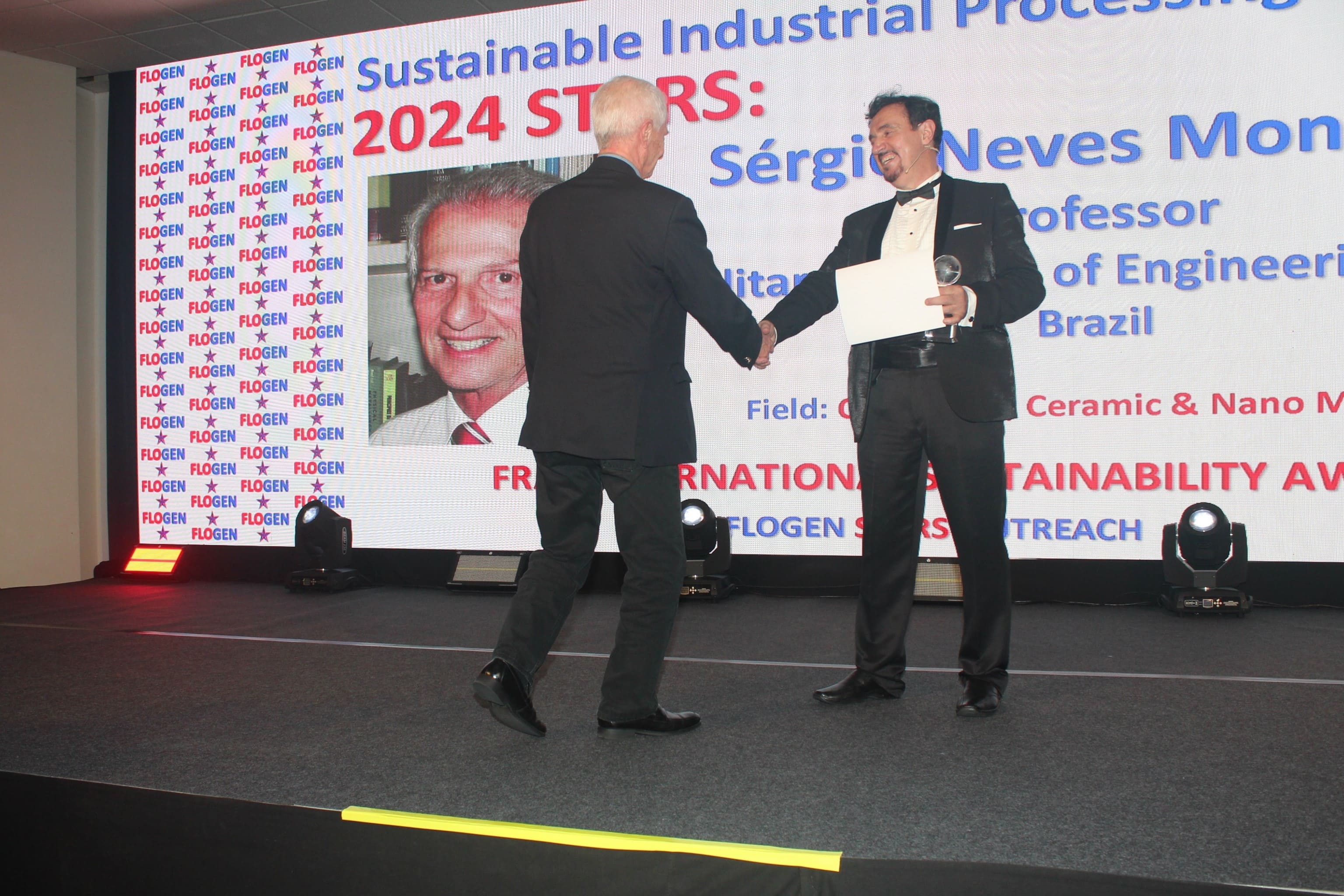 Dr. Florian Kongoli congratulating Dr. Sergio Monteiro during the FLOGEN SIPS 2024 award ceremony