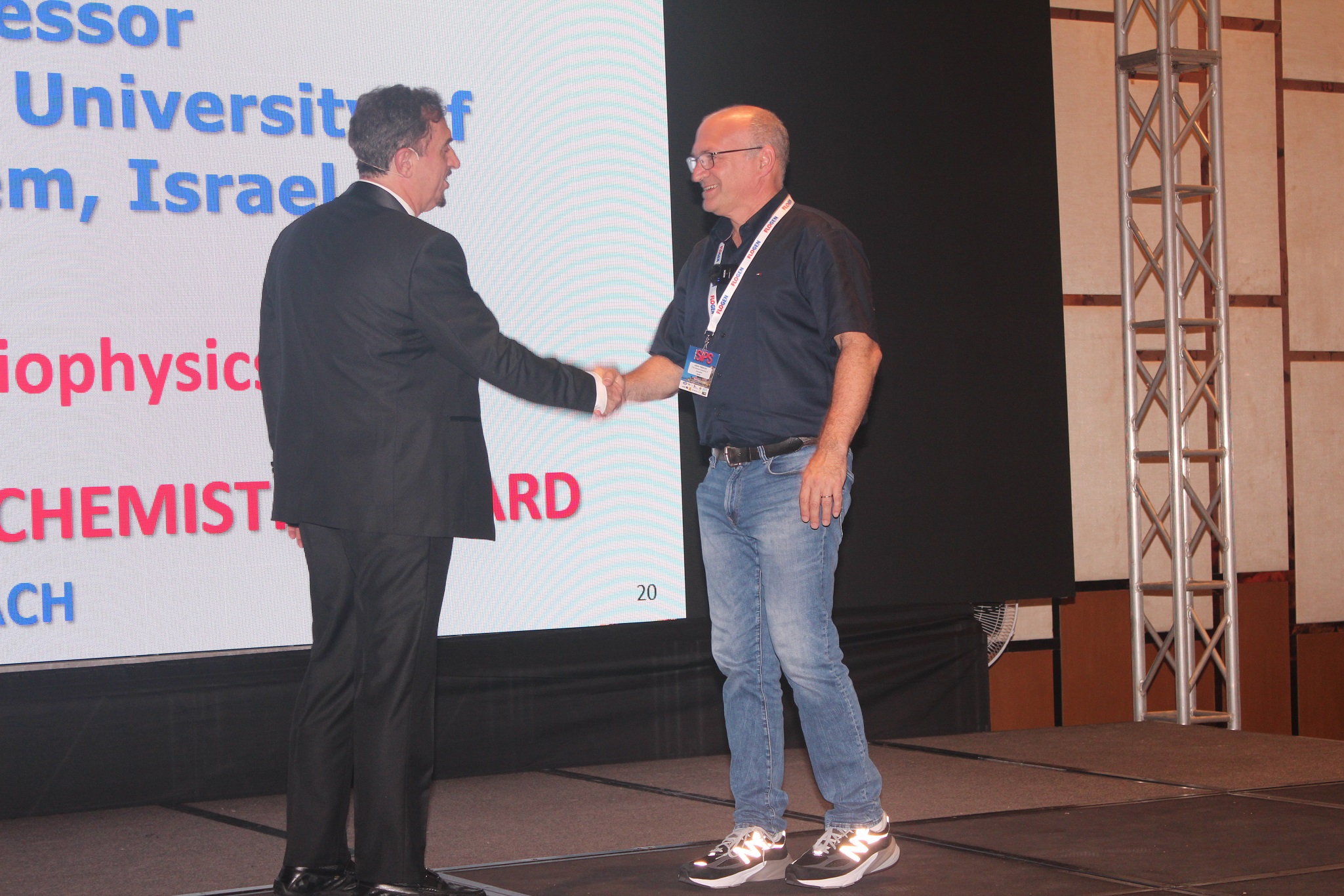 Dr. Florian Kongoli congratulating Dr. Assaf Friedler during the FLOGEN SIPS 2025 award ceremony