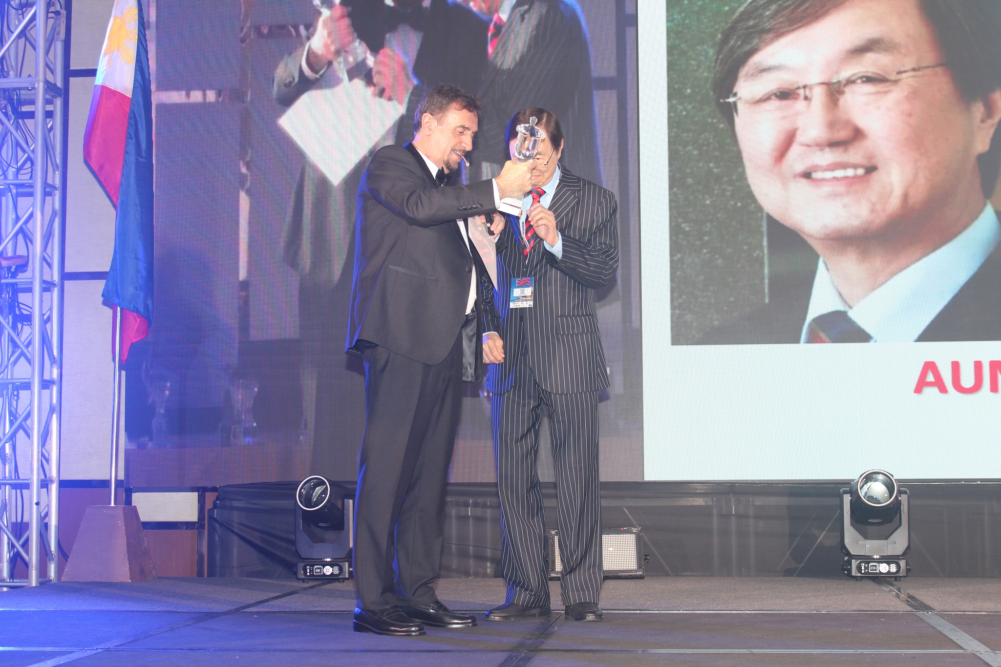 Dr. Florian Kongoli congratulating Dr. Charles Tang during the FLOGEN SIPS 2025 award ceremony