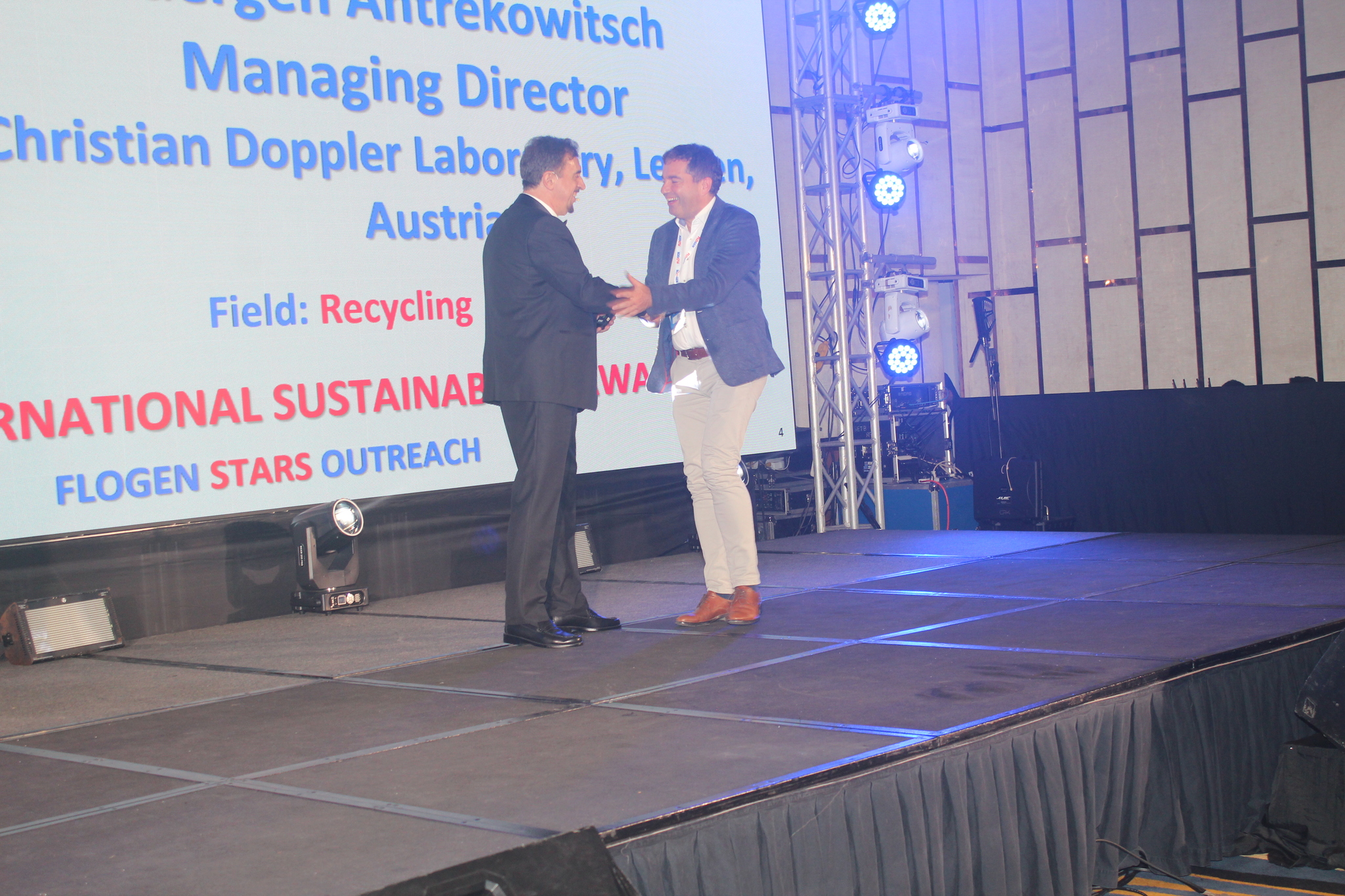 Dr. Florian Kongoli congratulating Dr. Juergen Antrekowitsch during the FLOGEN SIPS 2025 award ceremony