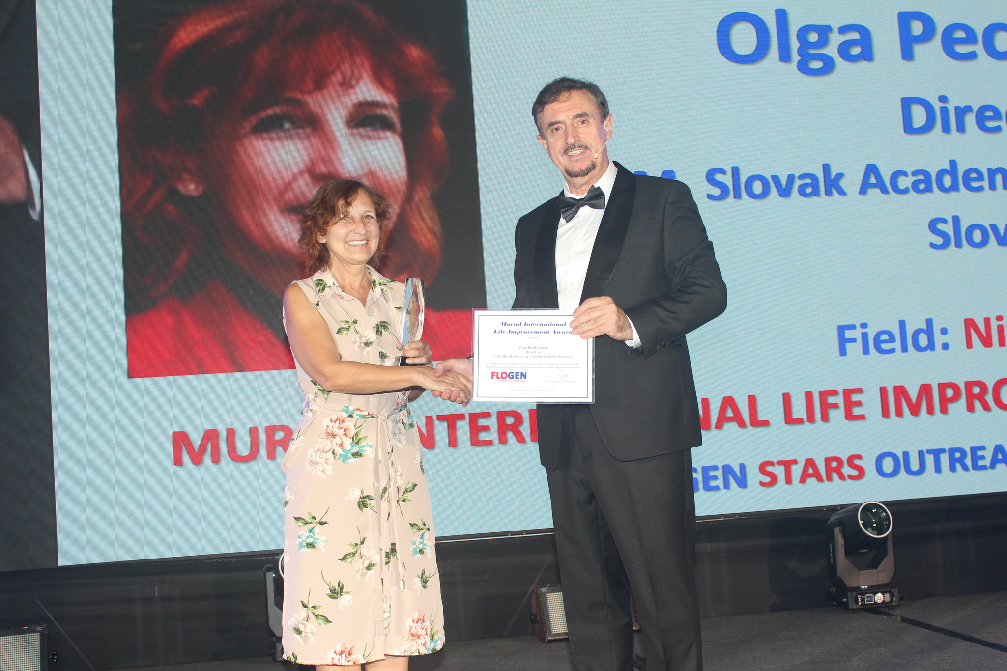 Dr. Olga Pechanova receiving the Murad International Life Improvement Award from Dr. Florian Kongoli at FLOGEN SIPS 2025