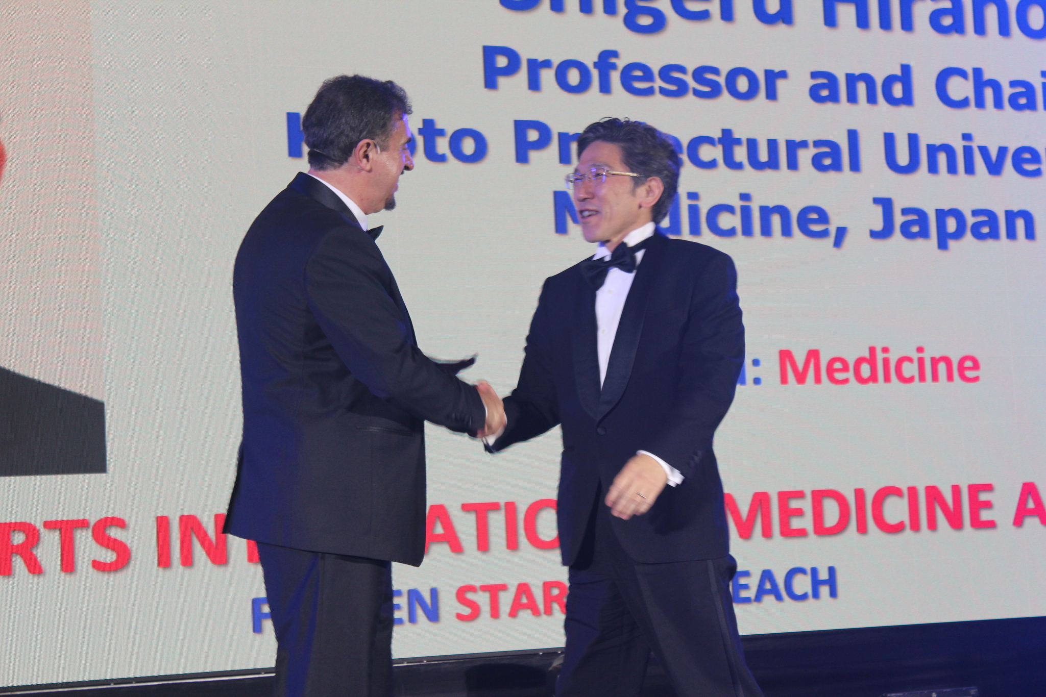 Dr. Florian Kongoli congratulating Dr. Shigeru Hirano during the FLOGEN SIPS 2025 award ceremony