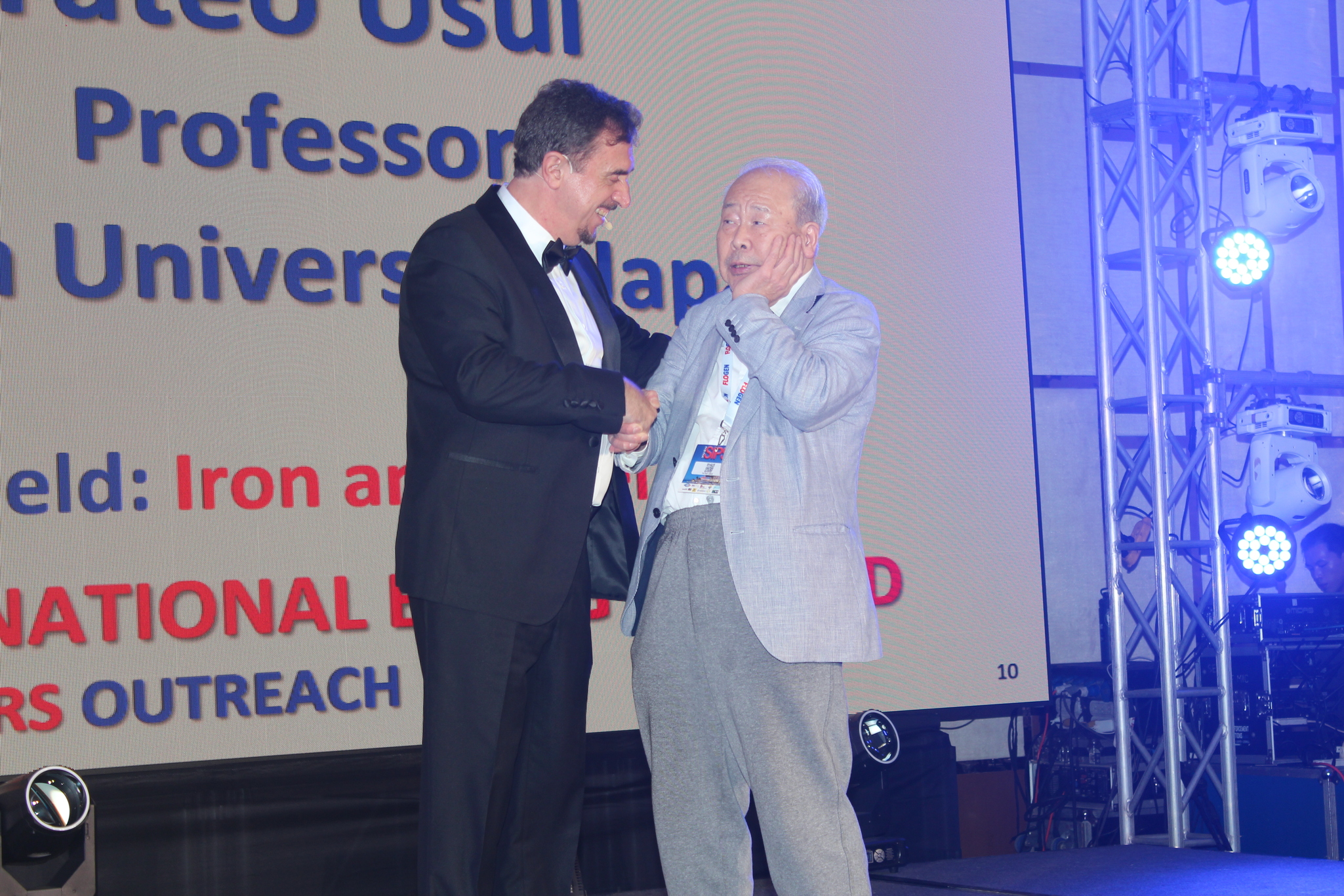 Dr. Florian Kongoli congratulating Dr. Tateo Usui during the FLOGEN SIPS 2025 award ceremony